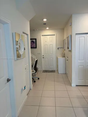 a view of a storage & utility room with refrigerator and mirror
