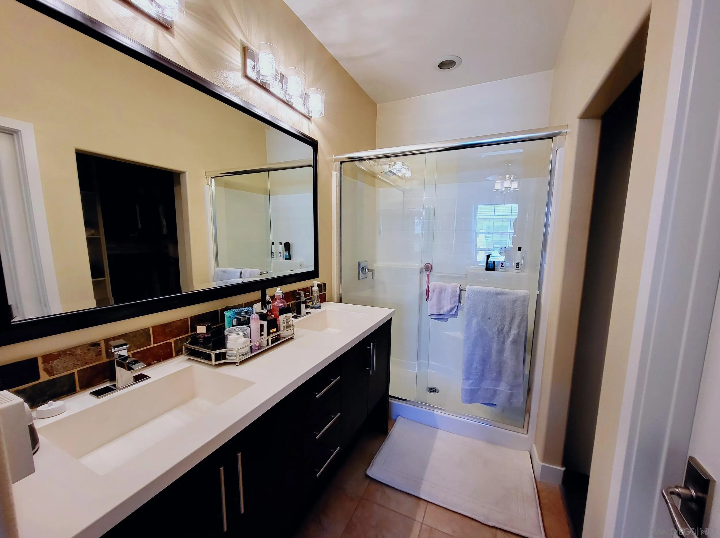 2152 Cosmo Way San Marcos, CA 92078 - Photo 12 of 28 a bathroom with a sink double vanity granite tub shower and a mirror
