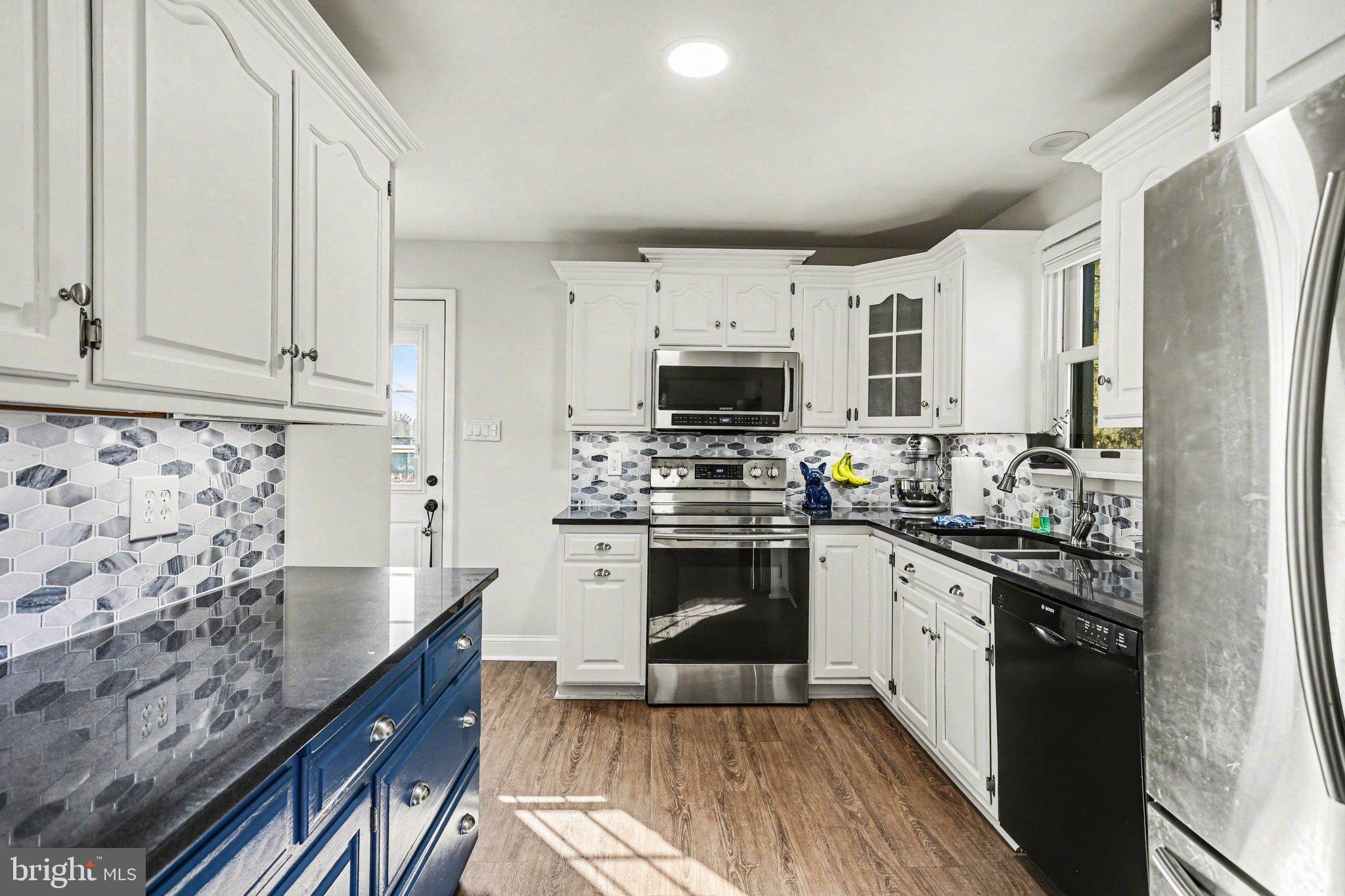 2848 Kissel Hill Road Lancaster, PA 17601 - Photo 7 of 36 a kitchen with stainless steel appliances granite countertop a stove top oven a sink a refrigerator white cabinets and wooden floor