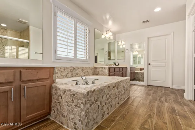 a bathroom with a tub sink and mirror