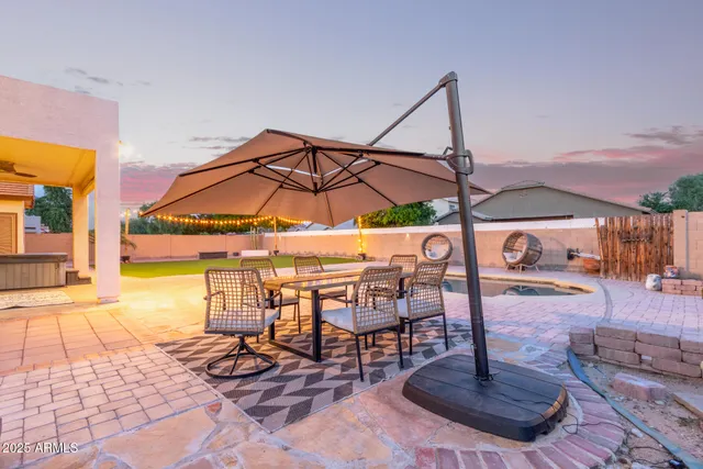 a view of a swimming pool with a table and chairs under an umbrella