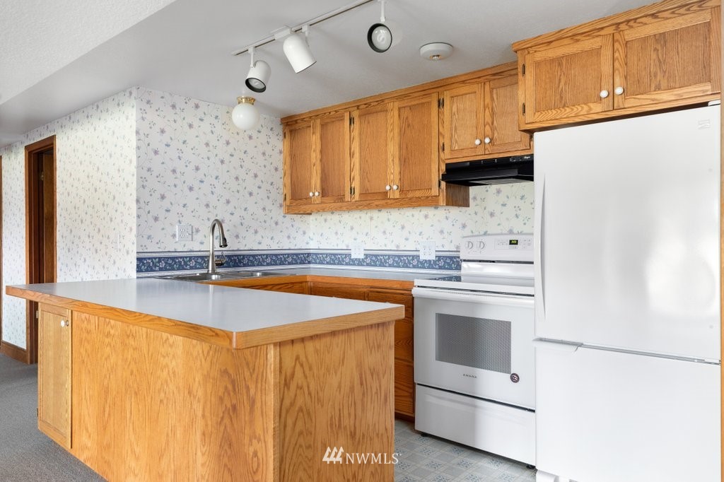 854 Devries Road Oak Harbor, WA 98277 - Photo 22 of 40 a kitchen with stainless steel appliances a sink stove and cabinets
