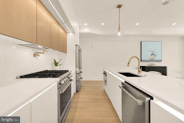 a kitchen with stainless steel appliances a sink a table and chairs