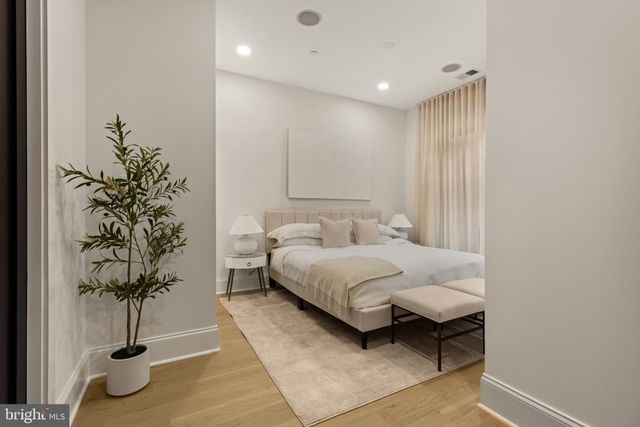 a bedroom with a large bed and a chandelier