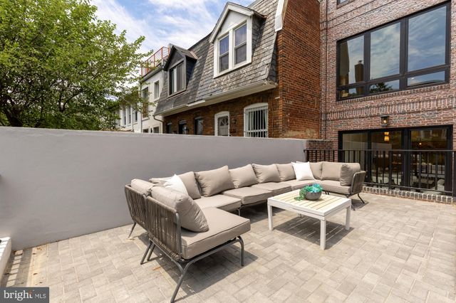 a view of a patio with couches table and chairs with potted plants