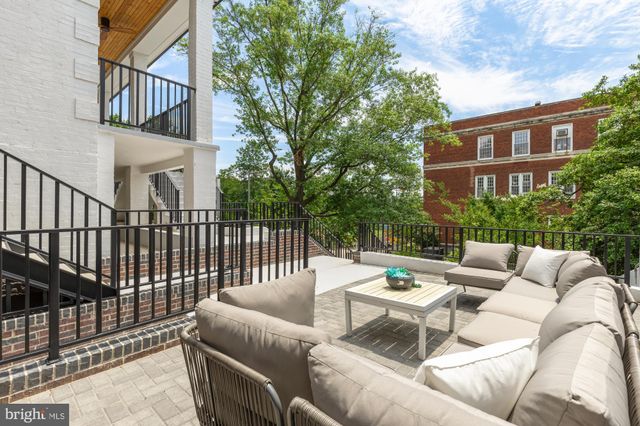 a view of a patio with couches table and chairs and potted plants