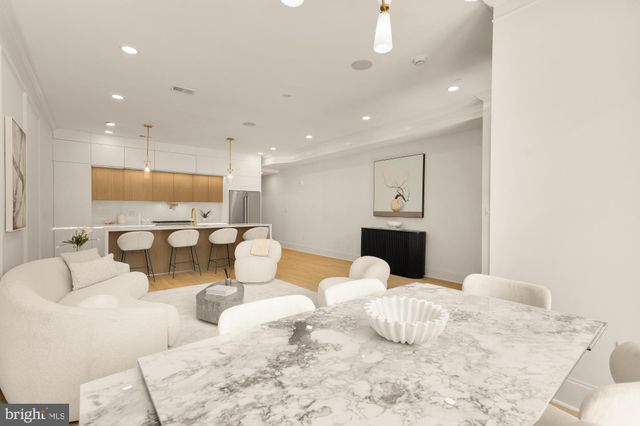 a large bedroom with a bed and a view of kitchen