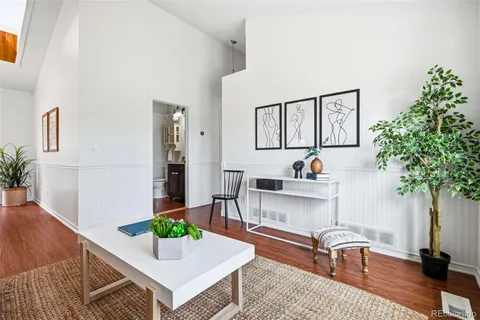 a living room with furniture a potted plant and a table