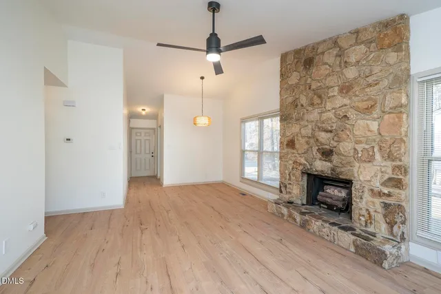a view of empty room with wooden floor and fireplace