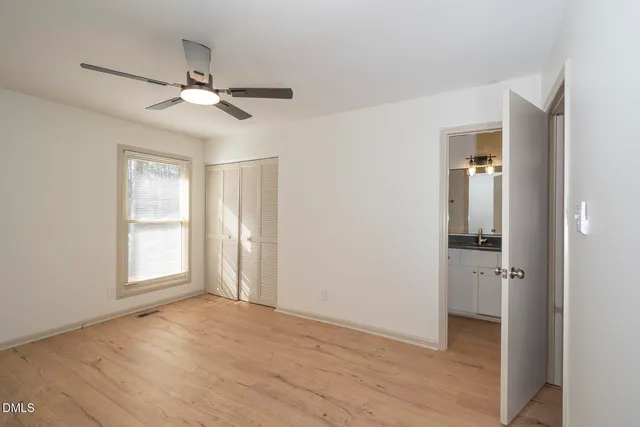an empty room with closet and windows