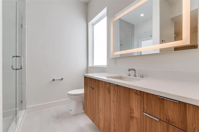 a bathroom with a sink a toilet and a window