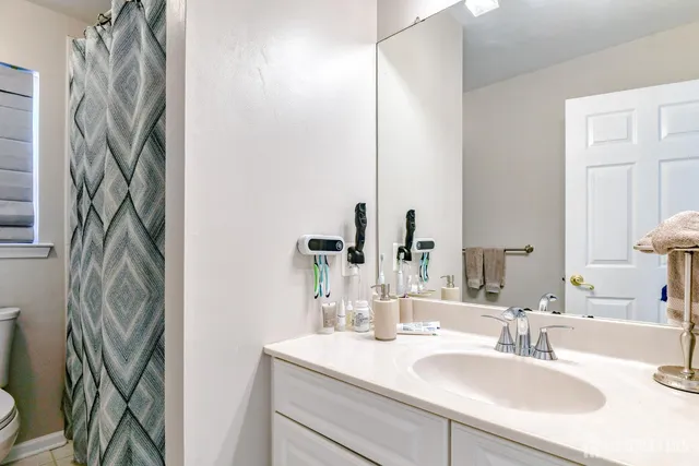 a bedroom with a bed a desk and chair with the wooden floor