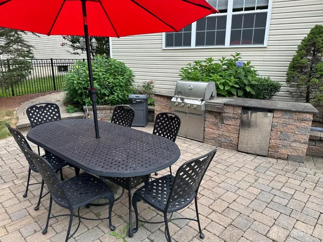 a view of a house with backyard sitting area and furniture
