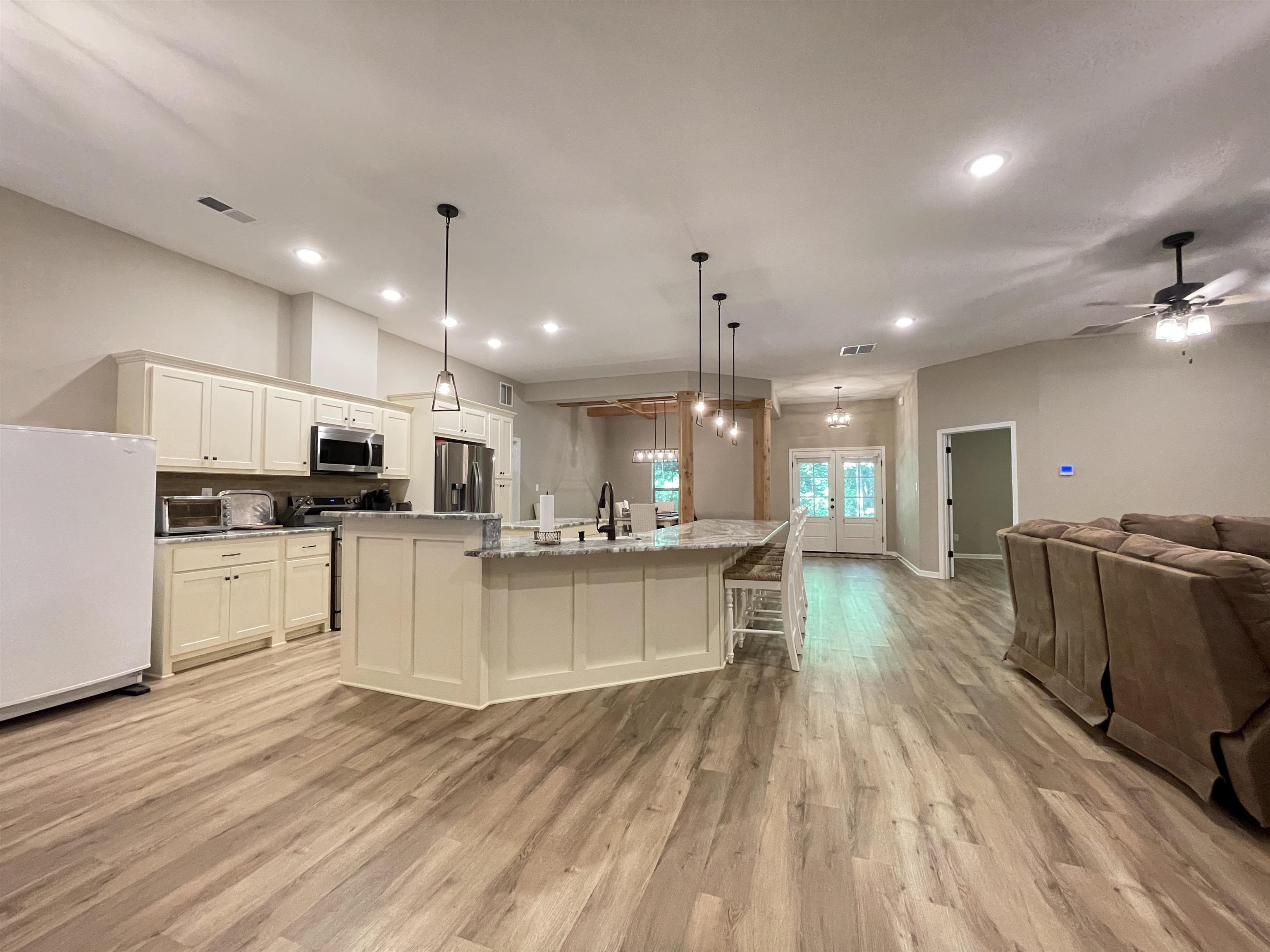 16691 Highway 59 Drummonds, TN 38023 - Photo 6 of 40 a kitchen with stainless steel appliances kitchen island granite countertop a sink cabinets and wooden floor