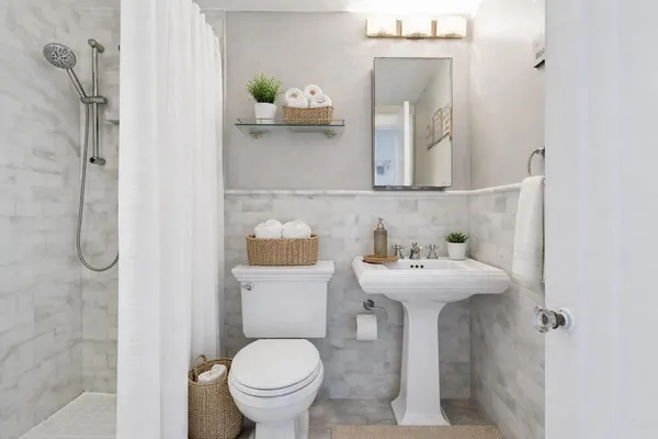 a bathroom with a sink toilet and mirror