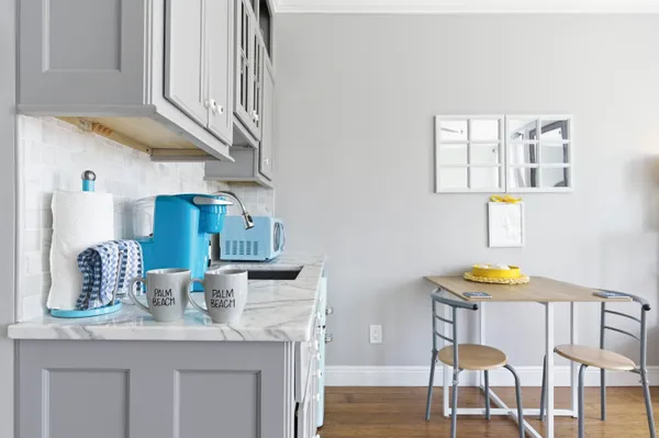 a kitchen with stainless steel appliances kitchen island granite countertop a table chairs in it and wooden floor