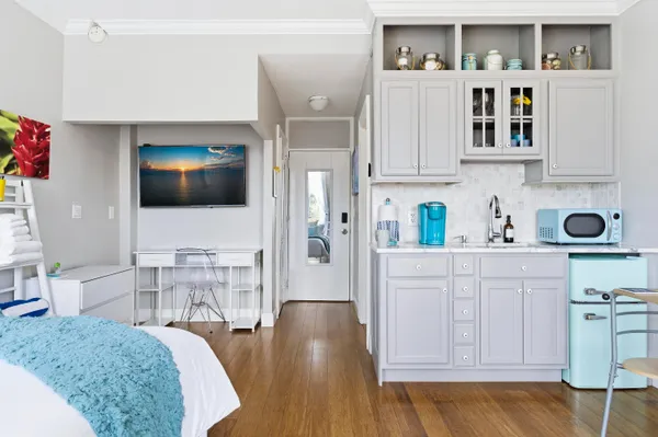 a kitchen with stainless steel appliances granite countertop a stove a sink a dining table and chairs with wooden floor