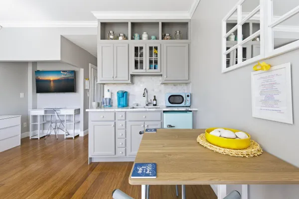 a living room with stainless steel appliances kitchen island a table and a couch