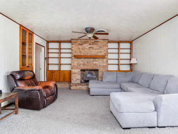 a living room with furniture a fireplace and a large window