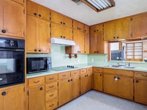 a kitchen with stainless steel appliances granite countertop a sink a stove and cabinets