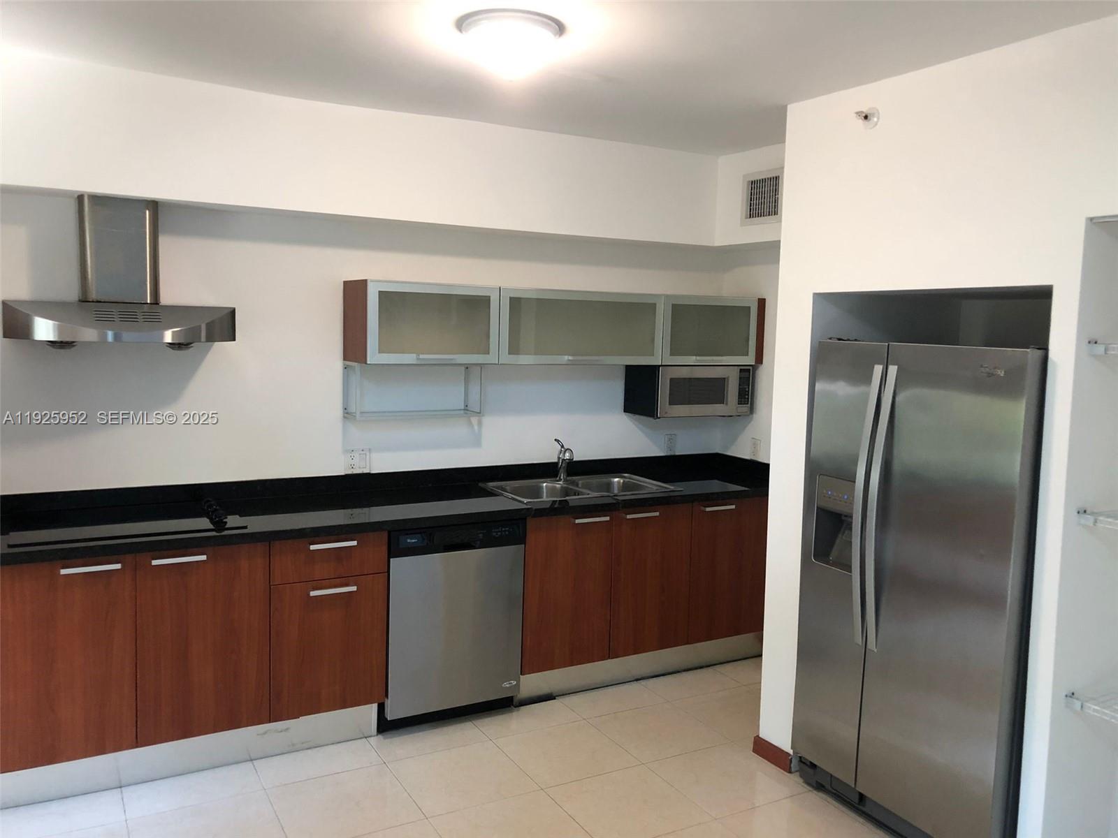 a kitchen with stainless steel appliances granite countertop a refrigerator and a sink