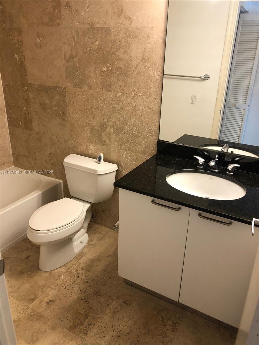 1650 Brickell Avenue, Unit 111 Miami, FL 33129 - Photo 11 of 23 a bathroom with a sink a toilet and mirror