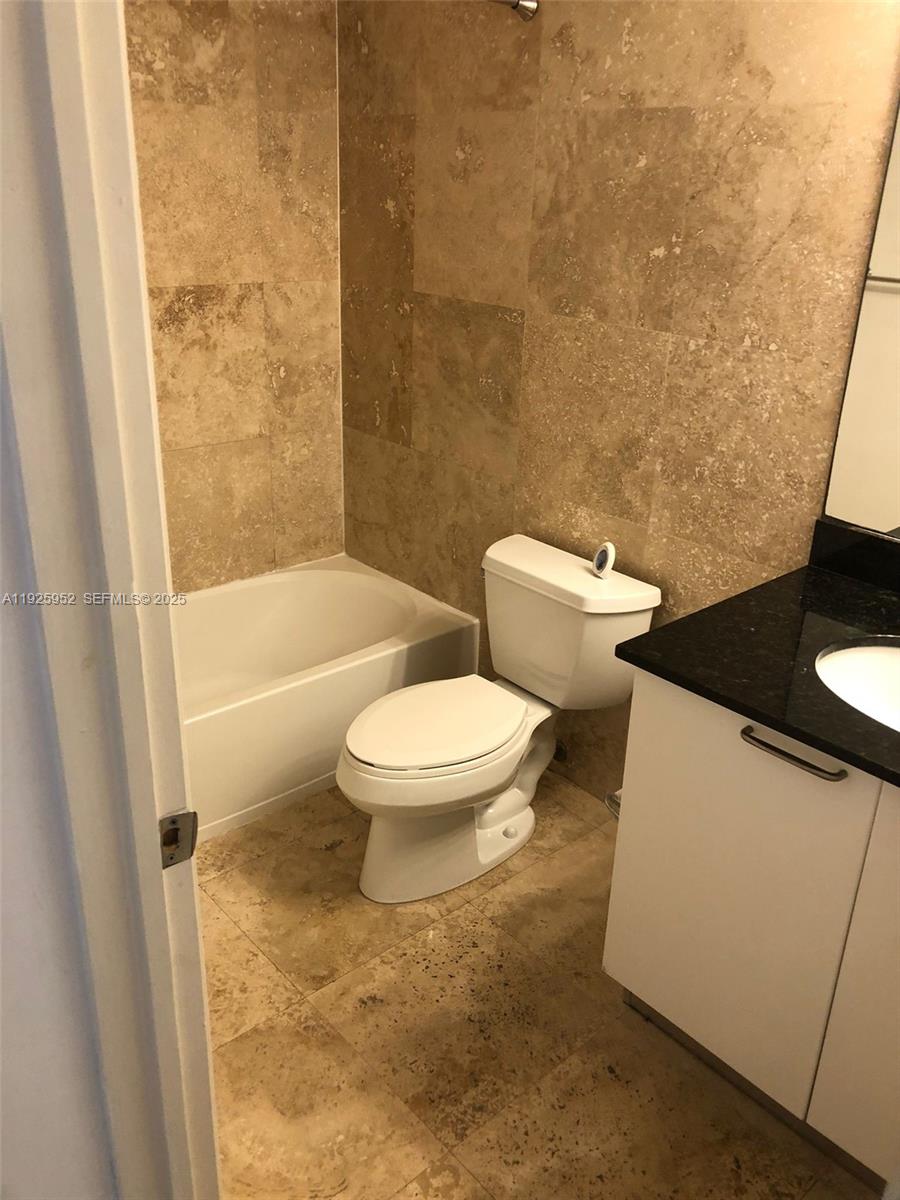 1650 Brickell Avenue, Unit 111 Miami, FL 33129 - Photo 15 of 23 a white toilet sitting next to a bath tub and a shower
