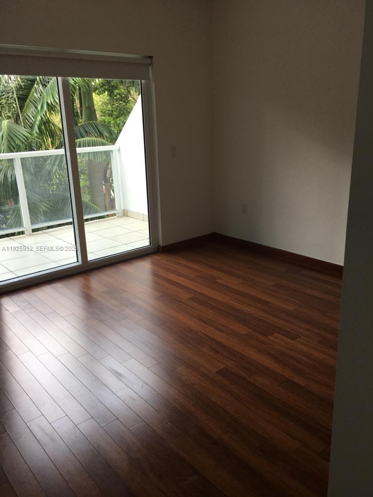 1650 Brickell Avenue, Unit 111 Miami, FL 33129 - Photo 7 of 23 a view of an empty room with wooden floor and a window