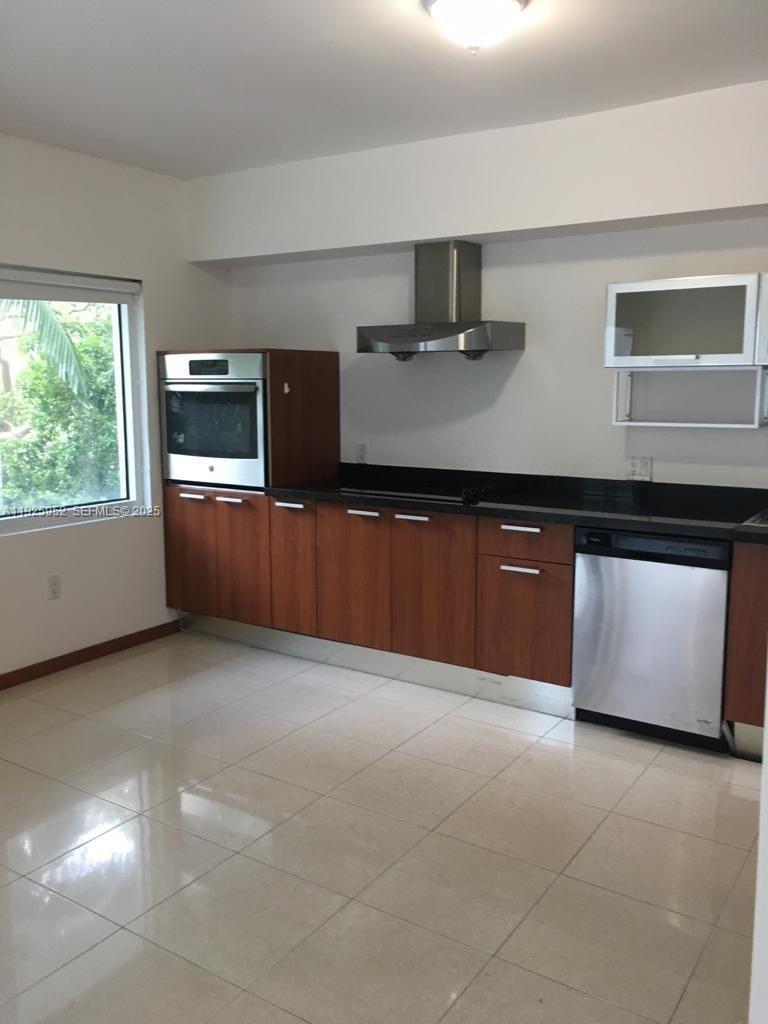 1650 Brickell Avenue, Unit 111 Miami, FL 33129 - Photo 8 of 23 a large kitchen with stainless steel appliances granite countertop a stove a sink and a microwave