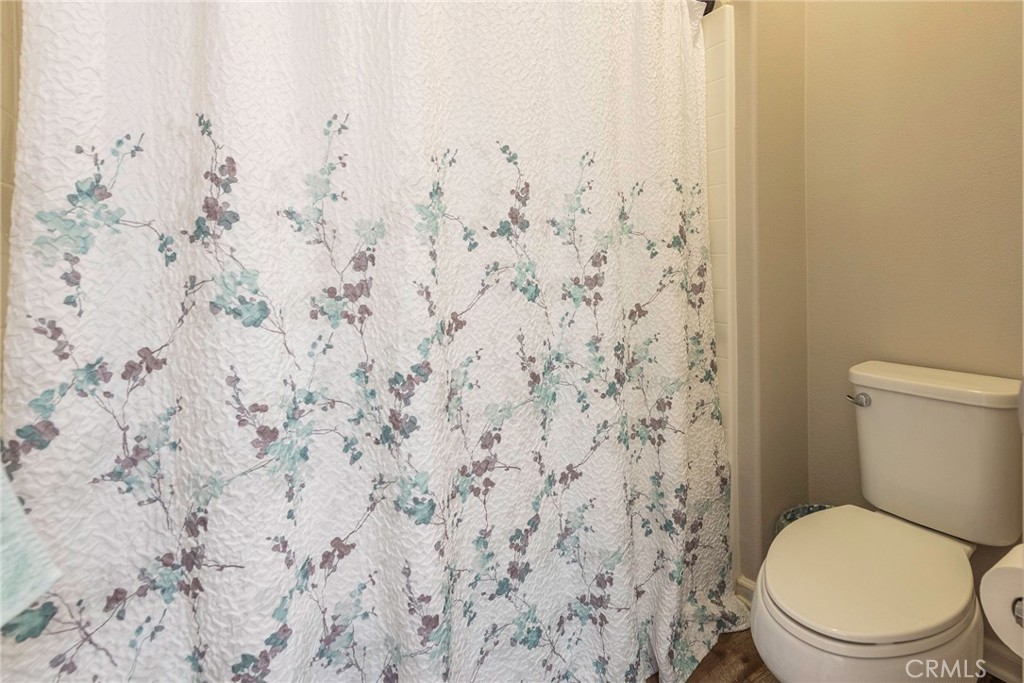 33837 Cansler Way Yucaipa, CA 92399 - Photo 23 of 49 a white toilet sitting next to a shower curtain