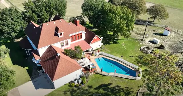 an aerial view of house with yard swimming pool and outdoor seating