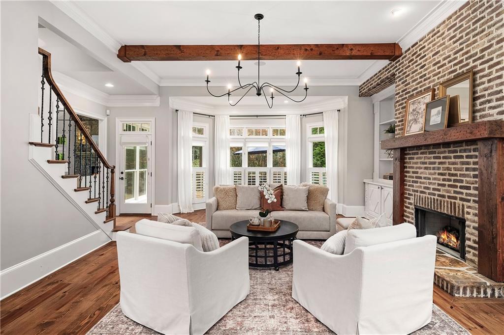 13200 Owens Way Milton, GA 30004 - Photo 16 of 113 a living room with furniture a fireplace and a chandelier