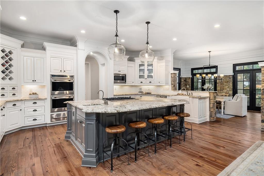 13200 Owens Way Milton, GA 30004 - Photo 28 of 113 a kitchen with stainless steel appliances kitchen island granite countertop a table chairs and a refrigerator