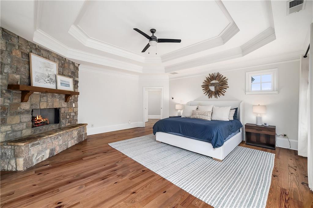 13200 Owens Way Milton, GA 30004 - Photo 47 of 113 a bedroom with a large bed a chandelier and a fireplace