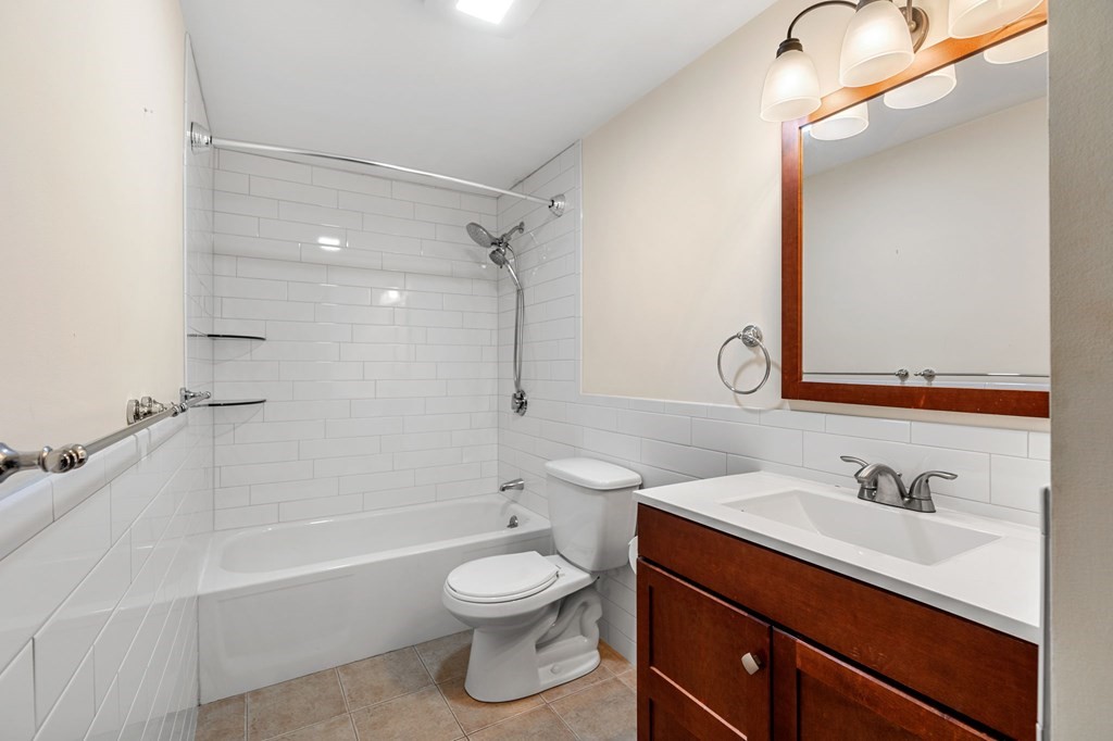 159 Franklin Street, Unit D2 Stoneham, MA 02180 - Photo 16 of 27 a bathroom with a sink vanity granite toilet tub and shower