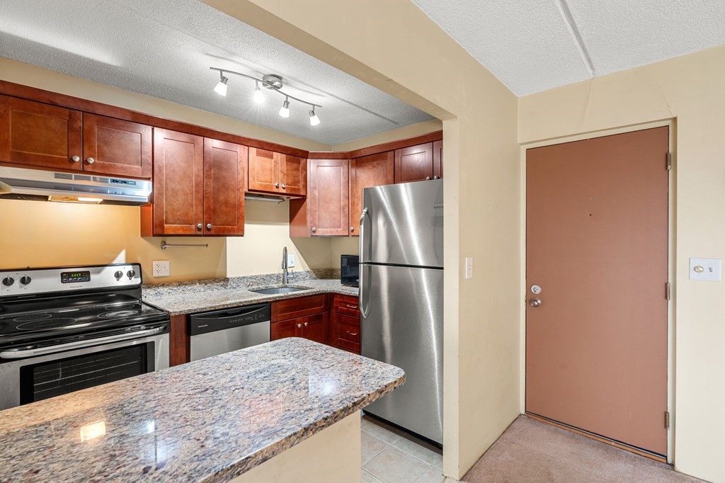 159 Franklin Street, Unit D2 Stoneham, MA 02180 - Photo 7 of 27 a kitchen with stainless steel appliances granite countertop a refrigerator and a stove top oven