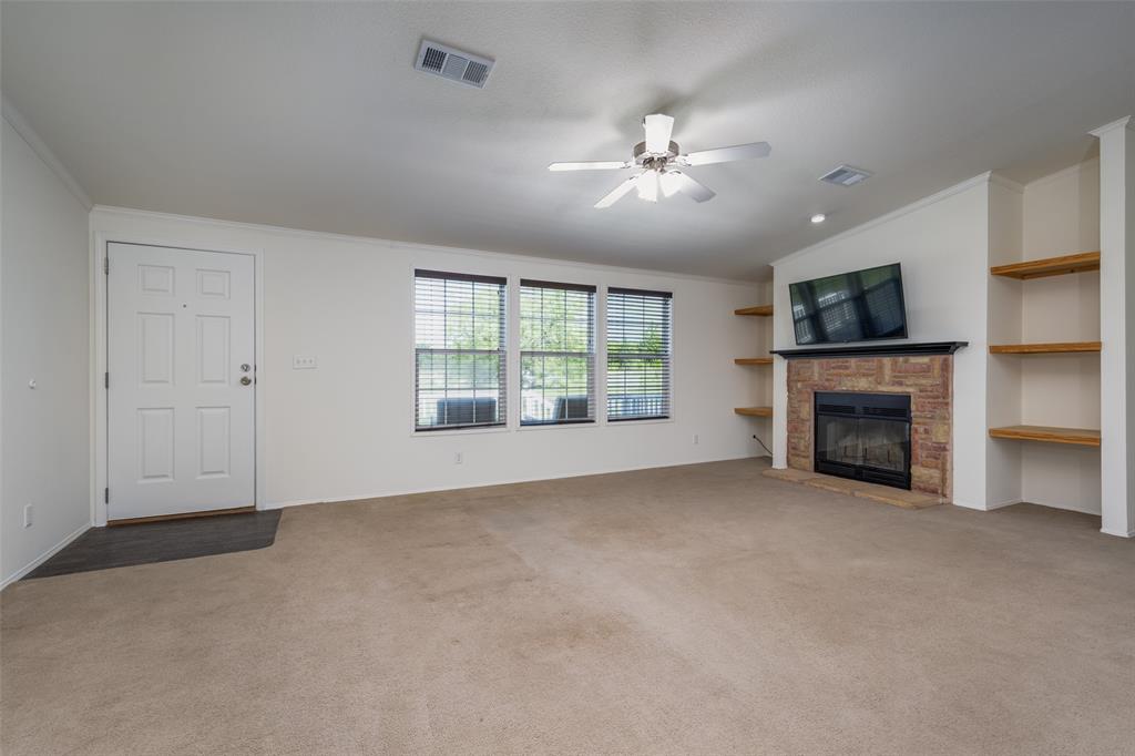 223 Slayden Drive Sunset, TX 76270 - Photo 8 of 24 a view of empty room with fireplace and fan