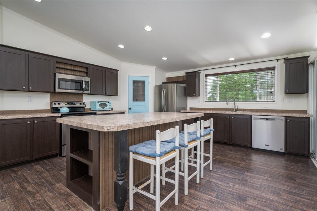 223 Slayden Drive Sunset, TX 76270 - Photo 10 of 24 a kitchen with stainless steel appliances granite countertop wooden cabinets a sink and a stove