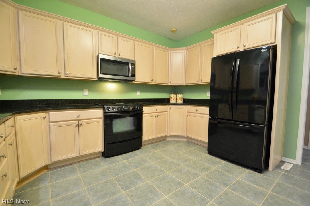 30247 Center Ridge Road, Unit 12 Westlake, OH 44145 - Photo 16 of 35 Large kitchen with plenty of upper and lower cabinets; includes range, newer microwave and refrigerator