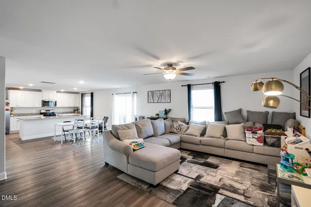 a living room with furniture and a view of kitchen