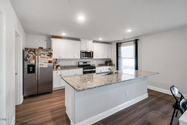 a living room with furniture and view of kitchen