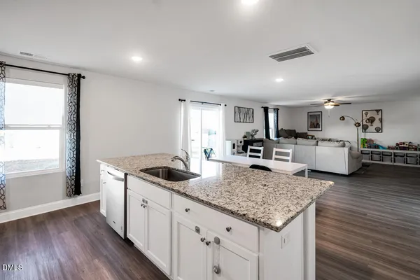 a kitchen with stainless steel appliances granite countertop a refrigerator a sink a stove a microwave and wooden cabinets