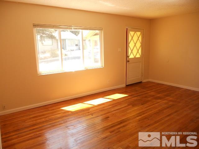 20 Volmer Way Reno, NV 89512 - Photo 4 of 24 a view of an empty room with wooden floor and a window