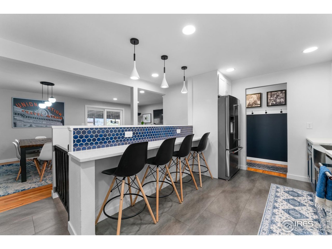 9261 Julian Way Westminster, CO 80031 - Photo 6 of 33 a kitchen with stainless steel appliances kitchen island granite countertop dining table chairs and a refrigerator