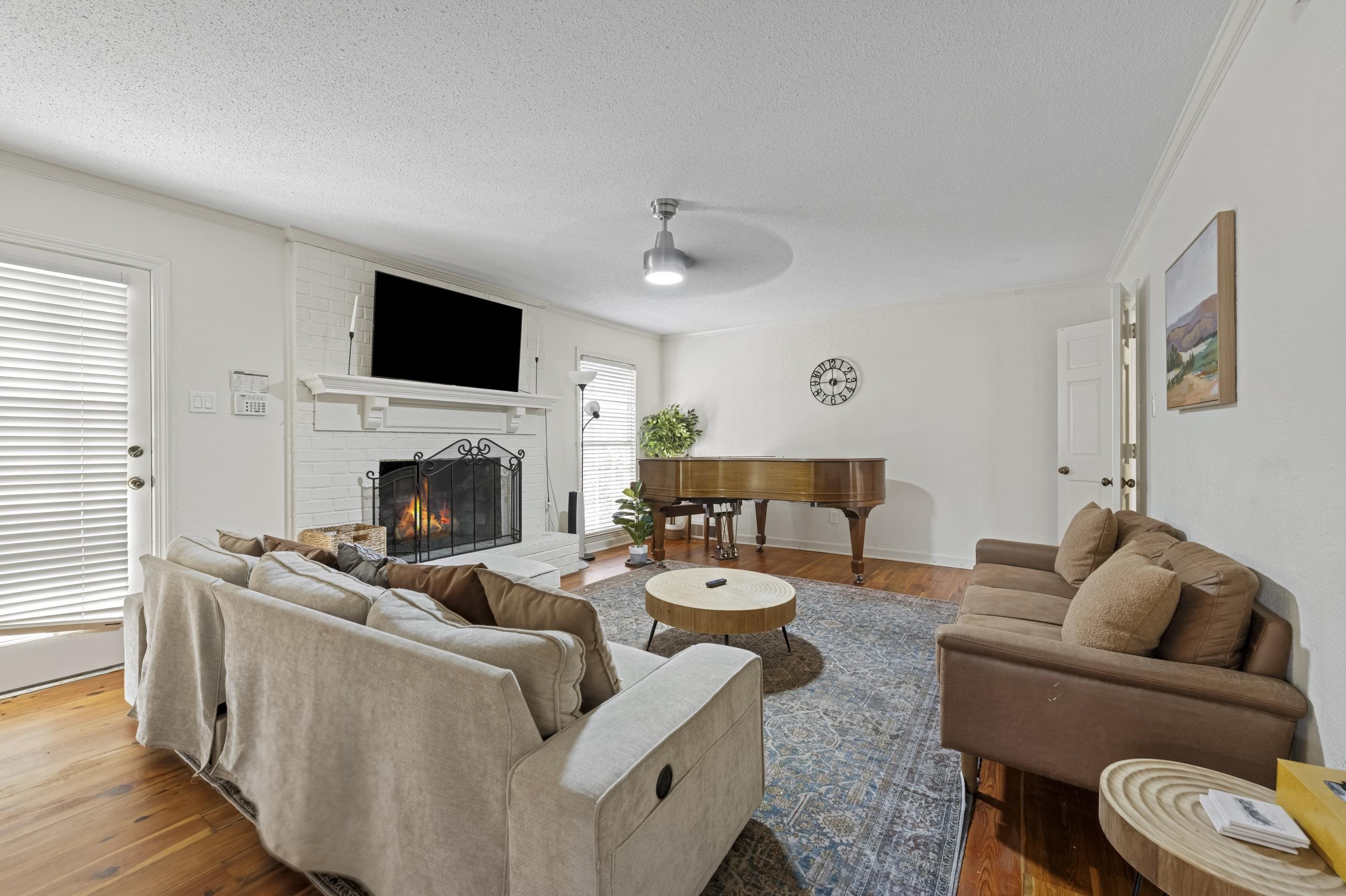 1316 Kirby Road Memphis, TN 38120 - Photo 11 of 30 a living room with furniture a flat screen tv and a fireplace