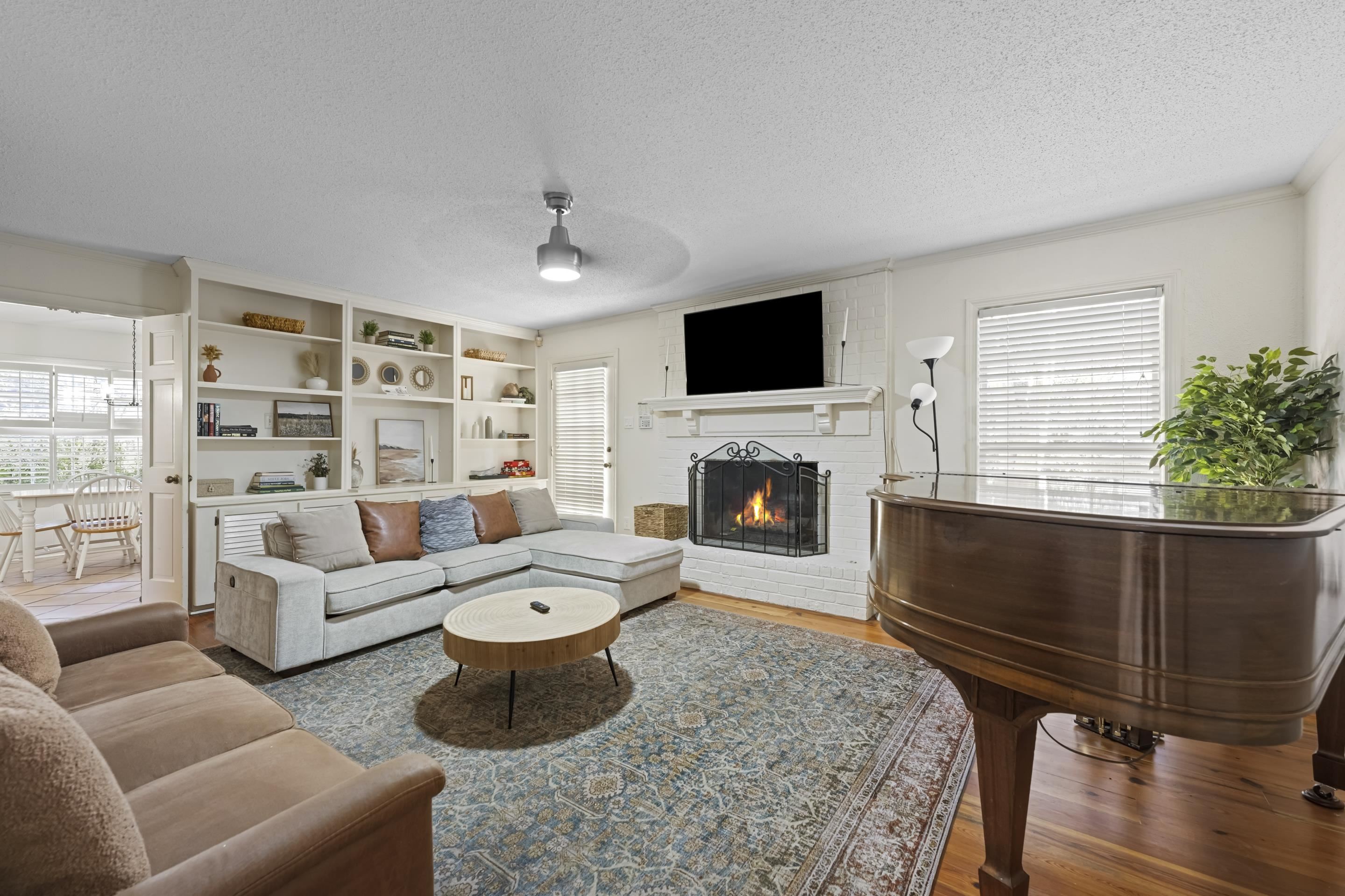 1316 Kirby Road Memphis, TN 38120 - Photo 19 of 30 a living room with furniture a flat screen tv and a fireplace