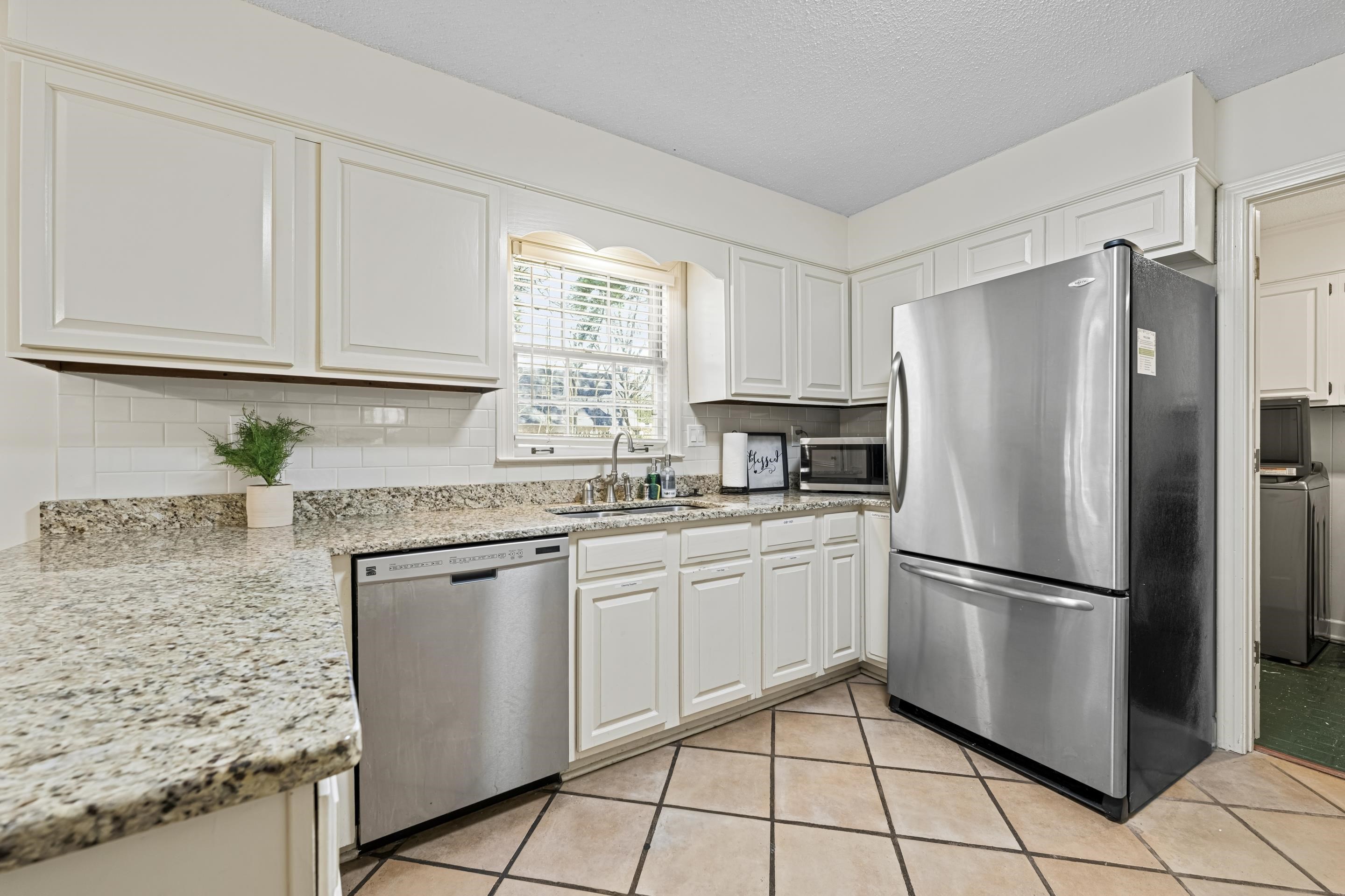1316 Kirby Road Memphis, TN 38120 - Photo 7 of 30 a kitchen with granite countertop a refrigerator sink stove and cabinets