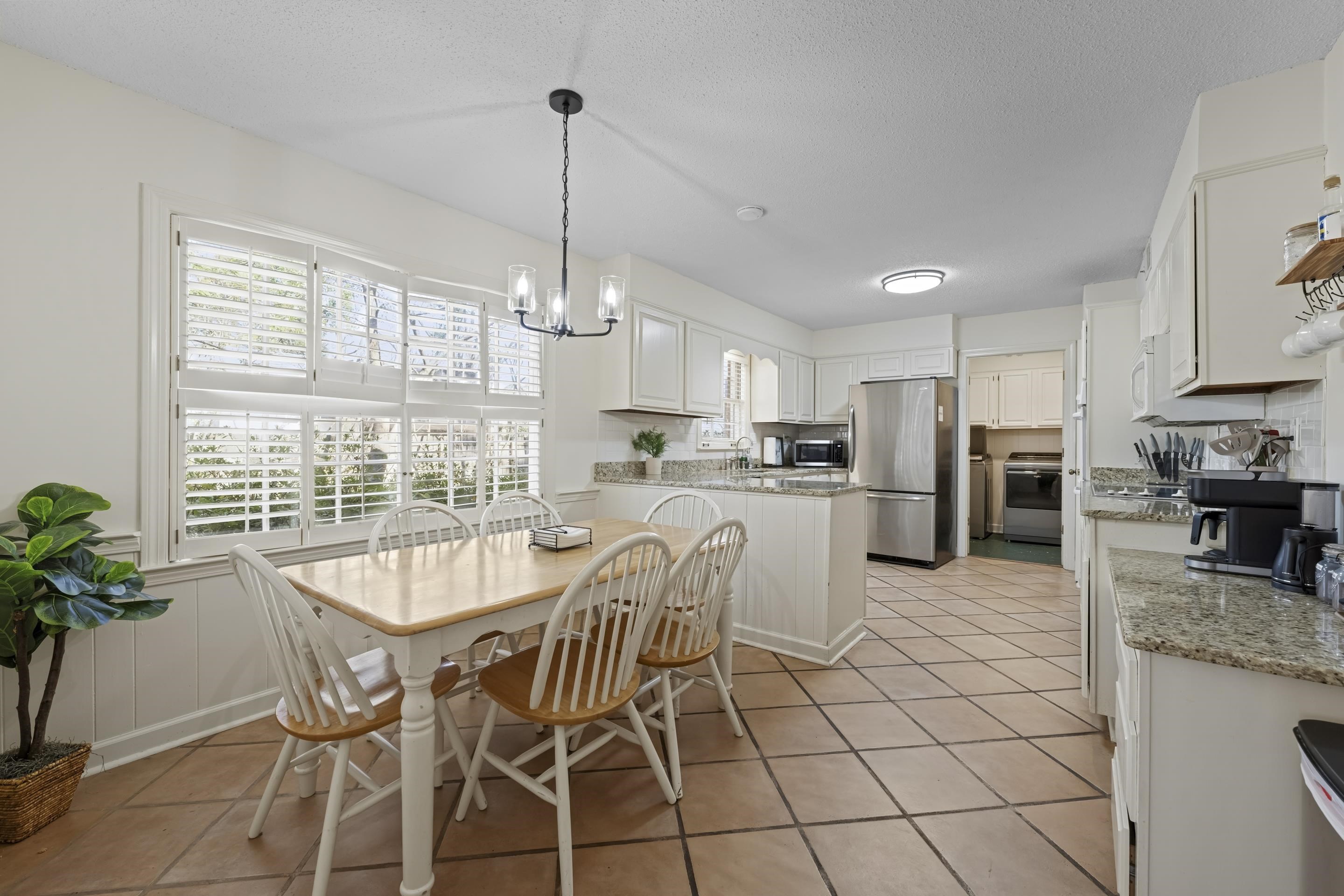 1316 Kirby Road Memphis, TN 38120 - Photo 9 of 30 a kitchen with stainless steel appliances a table and chairs in it