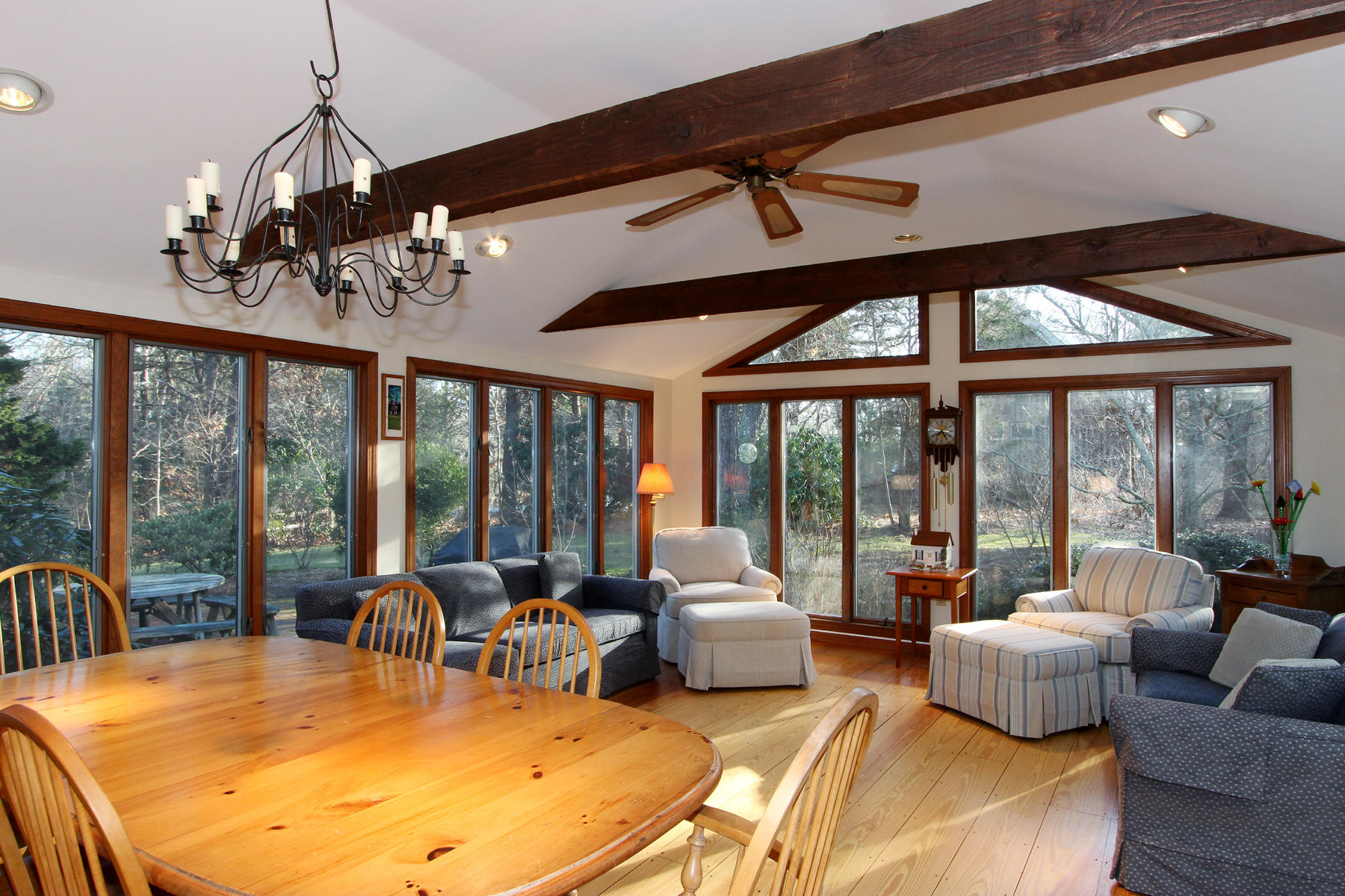10 Highland Road Eastham, MA 02642 - Photo 5 of 31 a view of a dining room with furniture a chandelier and large windows