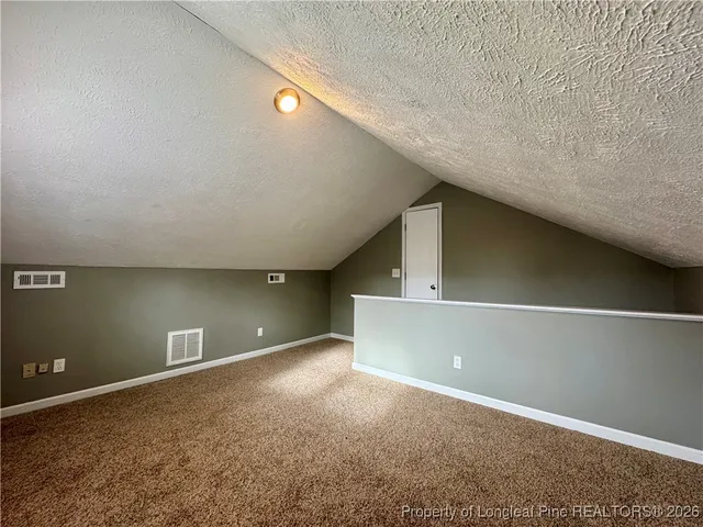 an empty room with windows and ceiling fan